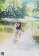 A young woman is splashing in the water. 