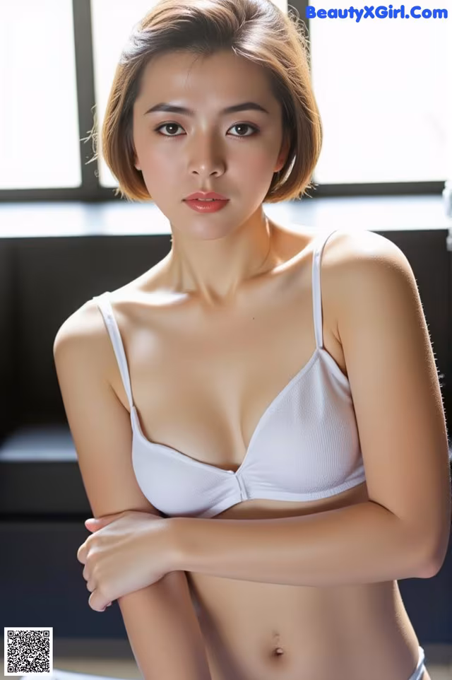 A woman in a white bra and panties posing for a picture.