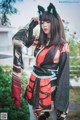 A woman in a black and red kimono with a cat ears headband.