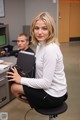 A woman sitting on a chair in an office.