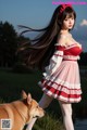 A woman in a red and white dress standing next to a dog.