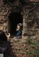 A man taking a picture of a naked woman in a tunnel.