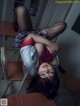 A woman laying on top of a desk in a classroom.