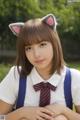 A girl in a school uniform with a cat ears on her head.